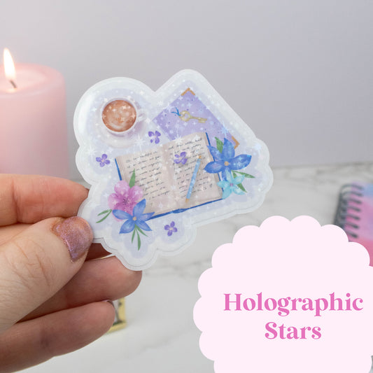 Heart-shaped holographic sticker with floral and book design held by a hand, with 'Holographic Stars' text overlay.