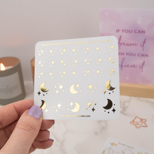 Close-up of Moon and Stars Clusters stickers with foiled quotes and intricate celestial details.